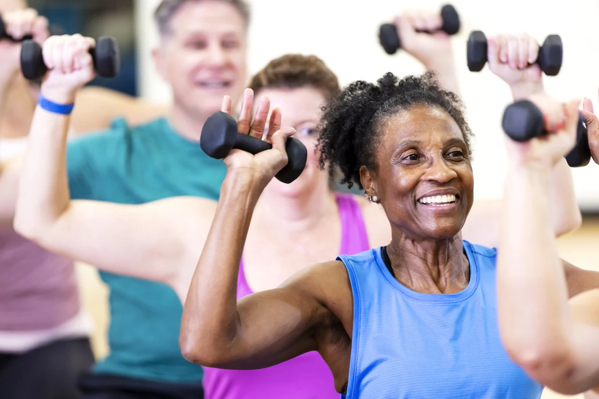 Fitness Classes for Seniors at The Village Tacoma Older adults smiling and participating in a group for fitness classes for seniors at The Village in Tacoma, WA.