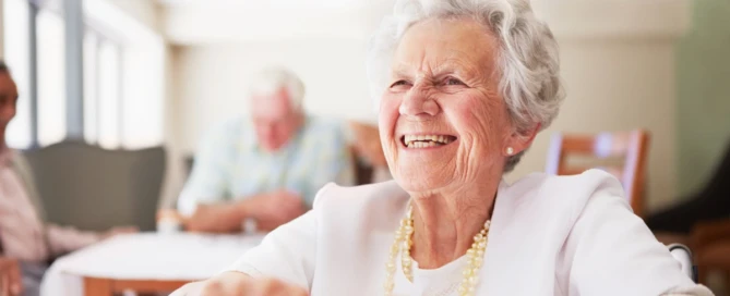 emotions of caregiving: Caregiver holding hands with older woman in a warm, supportive moment